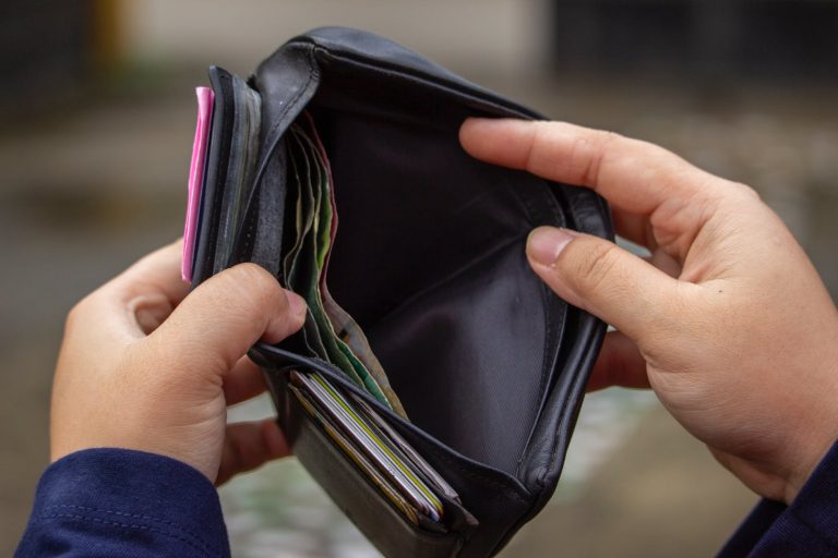 person holding a black wallet with money